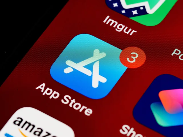 Close-up of App Store icon on iPhone screen with notification badge, highlighting app updates. App store listing experiments