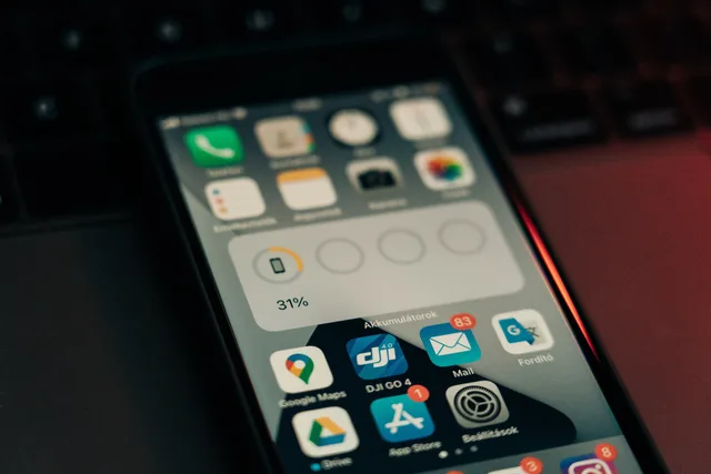 A smartphone with various apps on its screen placed on a keyboard, showing a 31% battery level. Setting notification frequency from user relevance